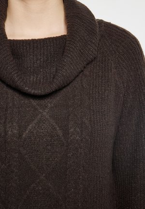 Pulover tricotat de culoare maro, cu guler răsucit, prezentând un model texturat și detalii cu nervuri, scoțând în evidență un material moale și cald.