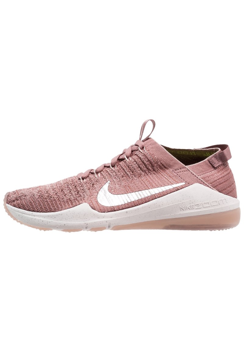 Pink knitted athletic shoe with a white swoosh logo, textured upper, minimal lacing, and transparent rubber sole.