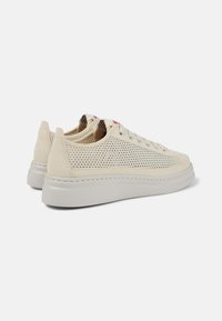 Sneaker bianche con tomaia in rete testurizzata, dettagli in pelle liscia e suola ammortizzata. Presentano cuciture sottili e logo dettagliato.