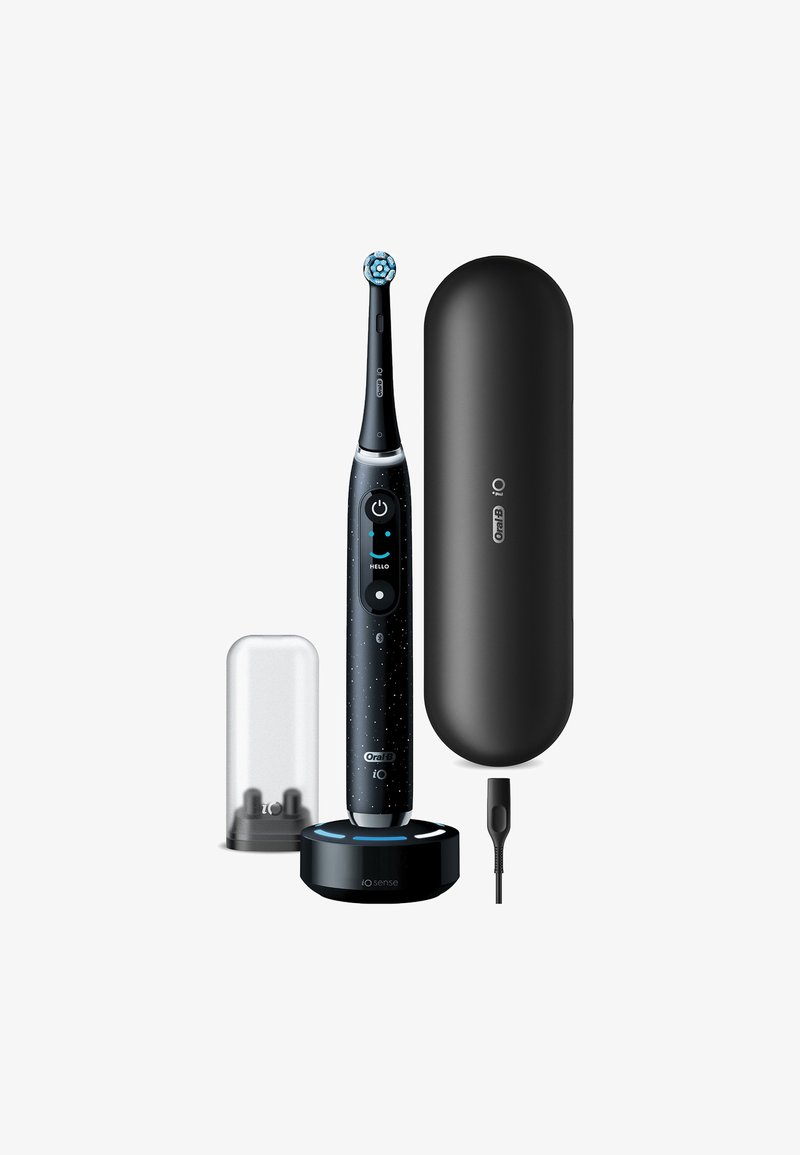 Brosse à dents électrique avec un design noir et tacheté ; comprend une base de chargement, un étui de protection et un capuchon de voyage transparent. Présente une tête de brosse ronde.