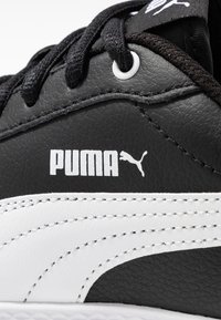 Juodi odiniai sportbačiai su baltais akcentais, pasižymintys tekstūruota paviršiumi, juodais raišteliais ir išsiskiriančiu baltu Puma logotipu šone.