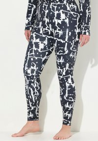 Leggings realizzati in tessuto elastico, caratterizzati da un motivo astratto in bianco e nero con schizzi e forme geometriche. Design aderente e slanciato.