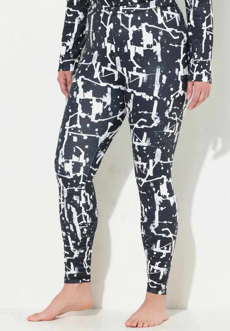 Leggings realizzati in tessuto elastico, caratterizzati da un motivo astratto in bianco e nero con schizzi e forme geometriche. Design aderente e slanciato.