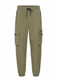 Pantalones cargo verde oliva con cintura ajustable por cordón, dos bolsillos laterales con cremallera y dos bolsillos en los muslos, con un parche de logo negro.