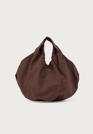 Sac fourre-tout en tissu marron foncé surdimensionné, de forme douce et arrondie, avec des poignées courtes, sur un fond blanc uni.