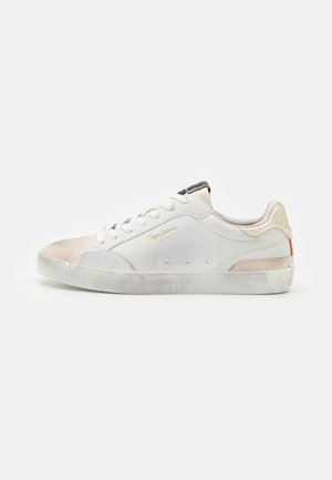Sneaker bianco con finitura testurizzata, dettagli in suede beige e crema, design con lacci piatti, e suola in gomma leggermente usurata.