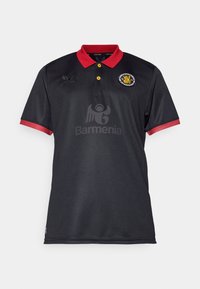 Zwarte poloshirt met rode kraag en manchetten. Voorzien van gele knopen, geborduurde logo's en een groot grijs gedrukt logo op de voorkant.