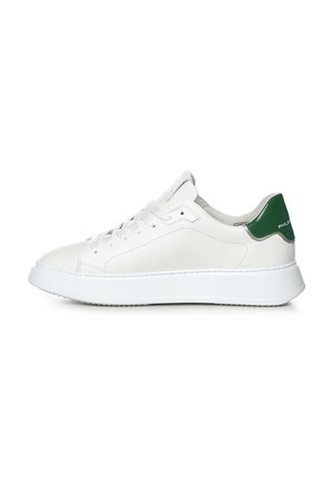Sneaker bianca low-top con linguetta verde sul tallone, lacci bianchi e suola spessa bianca, vista di profilo su sfondo uniforme.