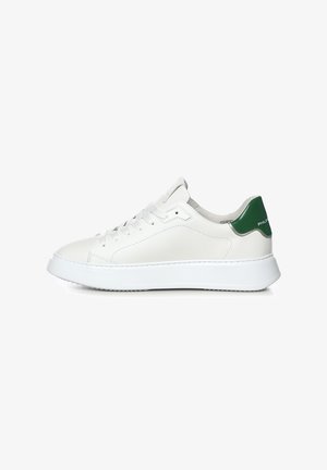 Sneaker bianca low-top con linguetta verde sul tallone, lacci bianchi e suola spessa bianca, vista di profilo su sfondo uniforme.