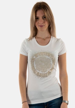T-shirt ajusté blanc avec un design graphique doré comportant du texte et des embellissements. Manches courtes et col rond, fabriqué à partir d'un tissu lisse.