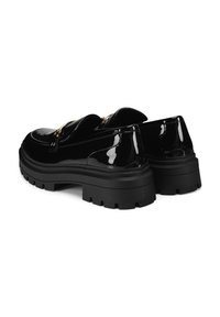 Mustad lakknahkist chunky platvormi loafers kuldse metalldetailiga ja paksude soonikute kummipõhjadega, nähtud tagant külgvaates.