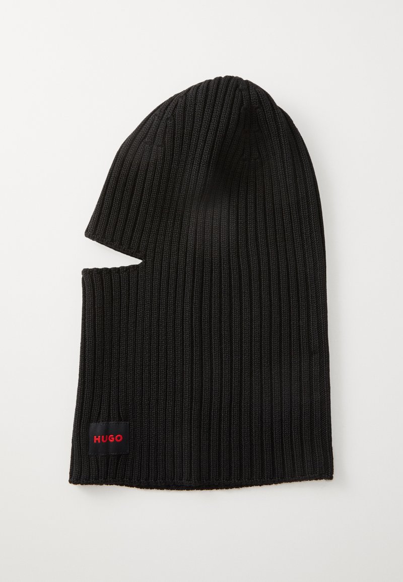 Căciulă neagră cu dungi, cu un design alungit și o decupare pe lateral. Prezintă o etichetă mică roșie „HUGO” brodată aproape de margine.