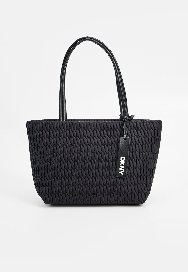 Schwarze gewebte Tragetasche mit zwei Griffen, strukturiertem Außenmaterial und einem Lederanhänger mit Logo. Geräumiges Design, ideal für den täglichen Gebrauch.