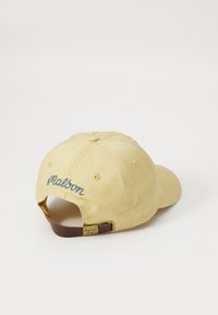 Yellow cotton baseball cap with embroidered blue text on the back, brown adjustable strap, and smooth texture. Features a rounded crown.