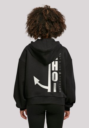 Black oversized hoodie with a drawstring hood, featuring a white graphic print and text on the back, made of soft fabric.