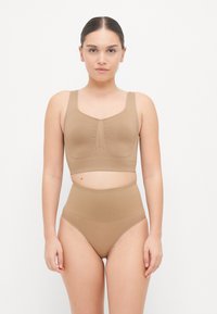 Bralette seamless marrone chiaro con spalline larghe e design arricciato, abbinata a slip alta vita in coordinato, realizzati in materiale liscio e elastico.
