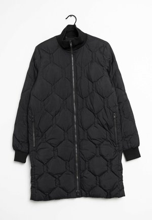 Sort quiltet lang frakke med høj krave, frontlynlås og to sidelommer med lynlås. Har diamantmønstret design og ribstrikkede manchetter.
