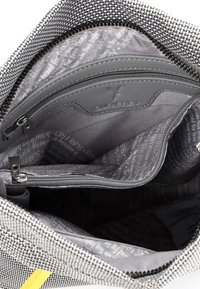 Vista dall'alto dell'interno di una borsa grigia testurizzata con numerosi scomparti con cerniera e foderata in tessuto grigio marchiato.