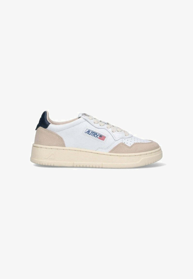 Sneaker bianche con accenti in suede beige e una linguetta sul tallone di colore blu scuro. Presentano una punta forata e un logo laterale con marchio. Sole in gomma.