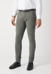 Gray slim-fit pants with front pockets, a black belt, and black loafers; fabric appears smooth with slight stretch.