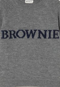 Suéter gris hecho de tela de punto suave con un cuello redondo y mangas raglán. La palabra "BROWNIE" se muestra de manera prominente en azul marino.