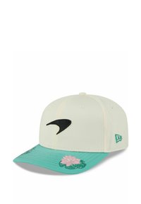 Weißer Hut mit schwarzem Logo auf der Vorderseite, mit einem türkisfarbenen Schirm, der mit rosa Blumenstickerei und grünen Blättern verziert ist.