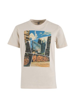 T-shirt beige avec un graphisme représentant un terrain de basket urbain, un panier, des graffitis et des bâtiments de la ville sous un ciel bleu avec des nuages.