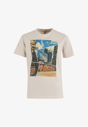 T-shirt beige avec un graphisme représentant un terrain de basket urbain, un panier, des graffitis et des bâtiments de la ville sous un ciel bleu avec des nuages.