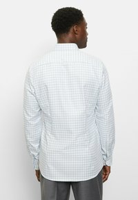 Langärmliges Hemd in hellblauem Karomuster aus Baumwolle, mit spitzem Kragen und geknöpften Manschetten. Rückansicht.