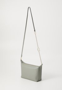 Grön läder crossbody-väska med dragkedjestängning, rektangulär form, justerbar axelrem och guldfärgade detaljer. Slät yta med minimal logotyp.