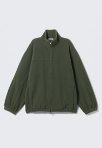 Jachetă din fleece verde închis cu fermoar integral frontal, guler înalt, manșete elastice și buzunare laterale, așezată pe o suprafață albă.