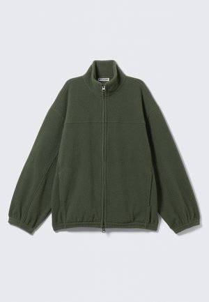 Veste polaire vert foncé avec fermeture éclair intégrale à l'avant, col montant, poignets élastiques et poches latérales, posée à plat sur un fond blanc.