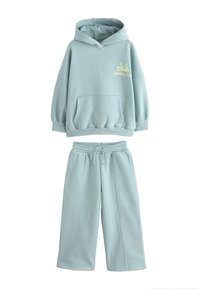 Vaaleansininen huppari ja siihen sopivat collegehousut, valmistettu pehmeästä kankaasta. Hupparissa on etutasku ja rinnan kohdalla kirjailtu teksti.