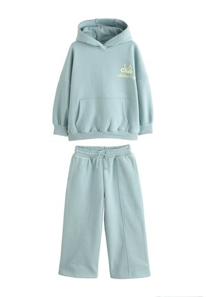 Vaaleansininen huppari ja siihen sopivat collegehousut, valmistettu pehmeästä kankaasta. Hupparissa on etutasku ja rinnan kohdalla kirjailtu teksti.