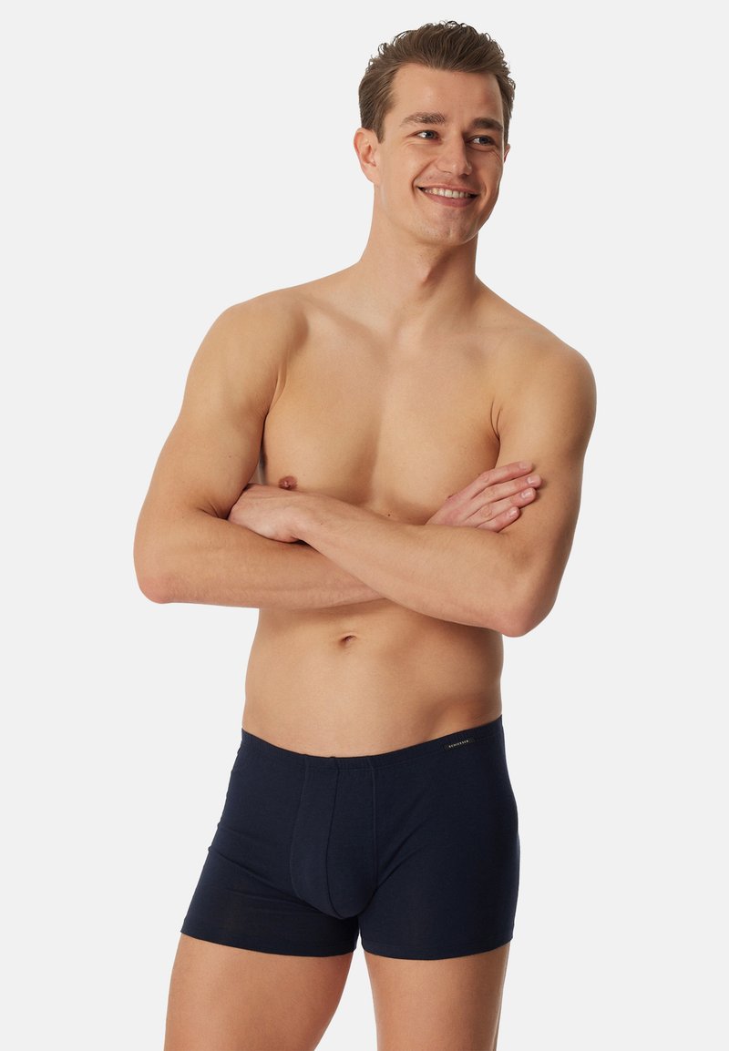 Boxers en coton bleu marine avec une coupe ajustée, dotés d'une poche avant, sans coutures visibles, et d'une ceinture élastique avec une petite étiquette logo.