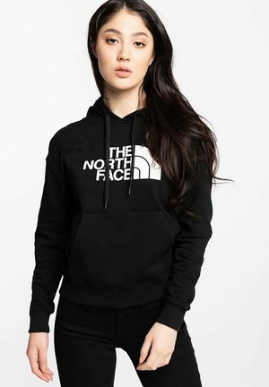 Sudadera negra de mezcla de algodón, cuenta con un bolsillo frontal, capucha ajustable con cordón, y un logo blanco impreso en el pecho.