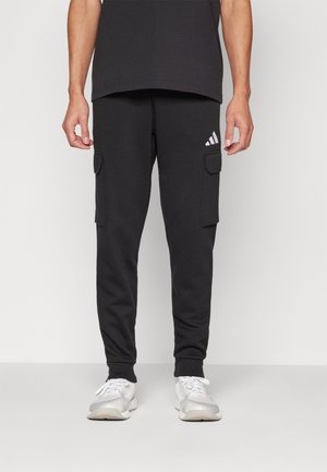 Zwarte joggerbroeken met cargozakken, elastische boorden en een subtiele witte Adidas-logo op de linkerdij. Zachte stof en rechte pasvorm.