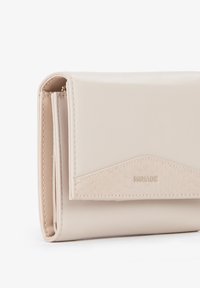 Portafoglio beige chiaro con pattina frontale testurizzata e corpo in pelle liscia. Presenta un logo discreto e cuciture precise. Forma rettangolare compatta.
