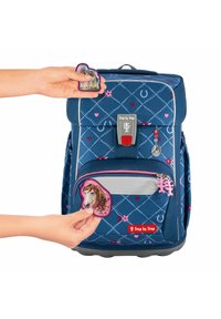 Navy blue backpack with heart patterns, a front zipper pocket, and removable badges. Features gray accents and textured material.