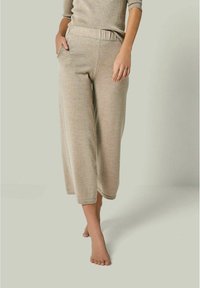 Beige weit geschnittene Hose aus strukturiertem Strickstoff mit elastischem Bund. Mit seitlichen Taschen und einer Länge bis zur Wadenmitte.