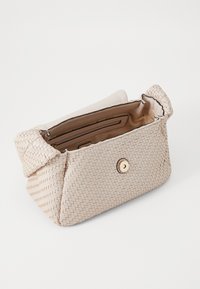 Sac en toile beige avec une surface texturée, des coins arrondis, une poche intérieure et une fermeture à bouton doré à l'avant.