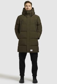 Piumino verde oliva con colletto alto e cappuccio, dotato di due tasche sul petto con zip, polsini a costine e design con isolamento in piuma.