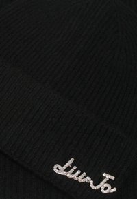 Berretto a coste nero con risvolto, caratterizzato da un logo in strass argentato nella parte anteriore, che offre un aspetto morbido e testurizzato.