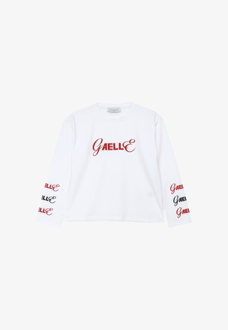 Camicia bianca a maniche lunghe con ricamo rosso "GAELLE" sul davanti e dettagli in nero e rosso sulle maniche. Materiale in cotone.