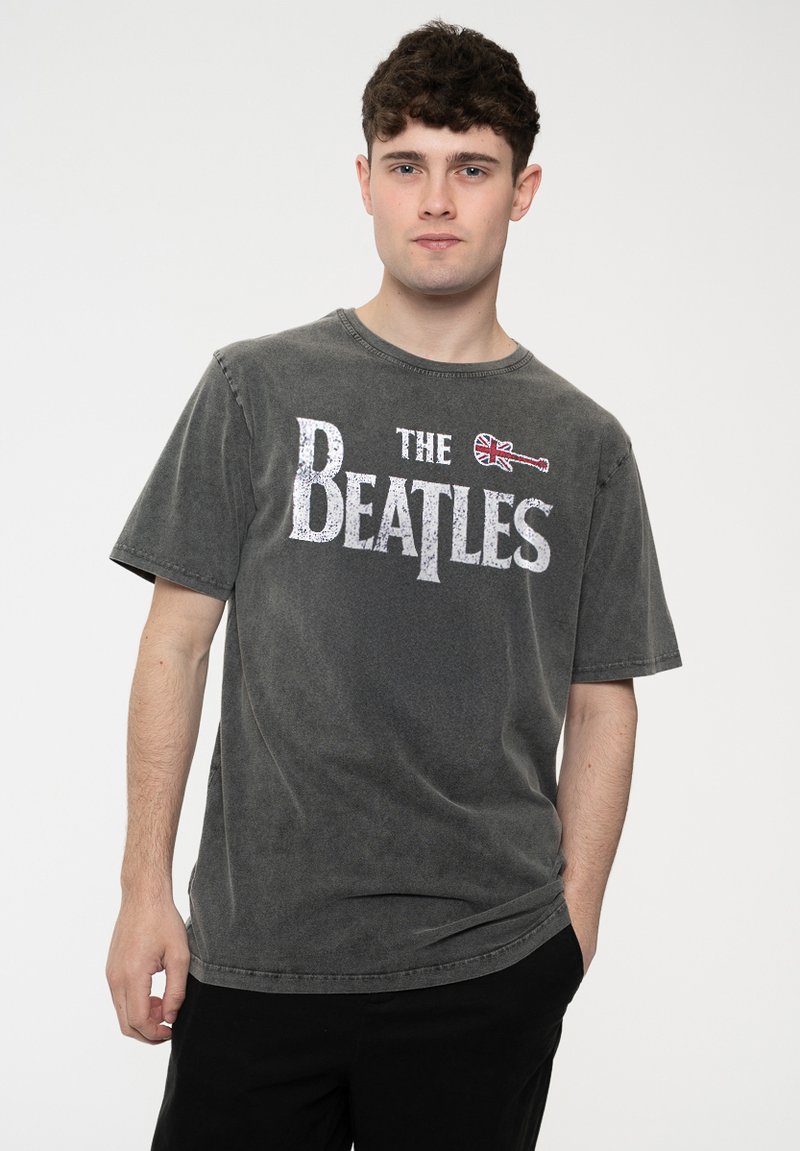 Gray short-sleeve t-shirt featuring "The Beatles" graphic with a guitar and Union Jack accent. Soft cotton material with a relaxed fit.