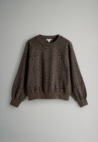 Hnedá mikina s čiernymi leopardími škvrnami, s dlhými nafúknutými rukávmi, rebrovanými manžetami a rebrovaným lemom na jednofarebnom sivom pozadí.