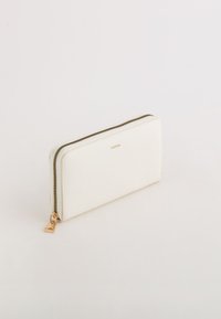 Witte textuur portemonnee met een gouden ritssluiting en hardware. Beschikt over een slank rechthoekig ontwerp met een subtiele merklogo.
