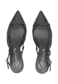 Zapatos negros de punta afilada con parte superior de malla, detalle de lazo en la parte delantera y tiras delgadas. Tienen un interior suave y una plantilla sutilmente marcada.