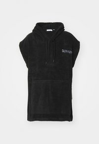 Črna kapuča pončo iz mehkega frotirskega blaga, z sprednjim žepom in vezenjem "CALVIN KLEIN" v beli barvi na prsih.