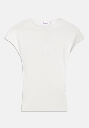 Camisa blanca de manga corta hecha de una suave tela de canalé. Cuello redondo; corte holgado con ligeras mangas tipo capucha. Etiqueta de la marca visible en el cuello.